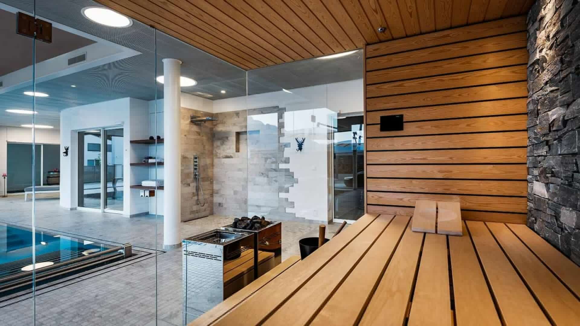 Sauna aussicht pool polarkiefer naturstein tauchbecken glasfront kueng wellness